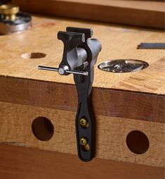 a tool is sitting on top of a workbench with holes and screws