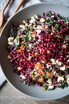 a bowl filled with vegetables and nuts on top of a table