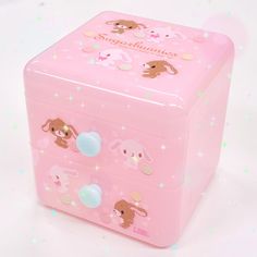 a pink toy box with some stickers on the front and sides, sitting on a white surface