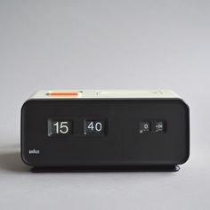 the alarm clock is black and white with orange numbers