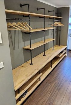 an empty walk in closet with wooden shelves and metal rails on the wall, next to a hardwood floor