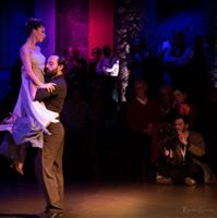 a man and woman dancing on stage in front of an audience