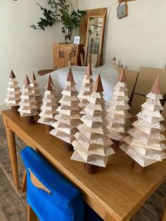 wooden christmas trees on a table in front of a mirror