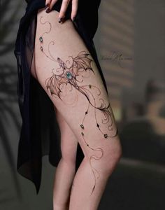 a woman's thigh with tattoos on her legs and the bottom part of her leg