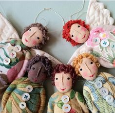 several dolls are hanging on the wall with their faces made out of fabric and buttons