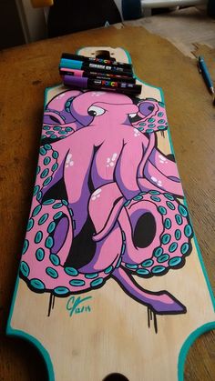 a wooden board with an octopus on it and some crayons next to it