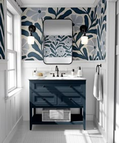 a bathroom with blue and white wallpaper on the walls, two sinks and a mirror