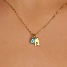 The Tiny Tag Initial Birthstone Necklace artfully combines personalized charm with a touch of color. This refined piece features a sleek gold tag, delicately engraved with your chosen initial, alongside a vibrant birthstone that dangles with light-catching allure. Perfect for celebrating a loved one's special month or adding a meaningful touch to your ensemble, this necklace serves as a daily reminder of personal significance and style. Birthstone dimension: 4 mm x 6 mm; Initial dimension: 10 mm Initial Birthstone Necklace, Gold Tag, Tiny Tags, Necklace For Mom, Necklace Birthstone, Letter Necklace, Birthstone Necklace, Daily Reminder, Birthstone Jewelry