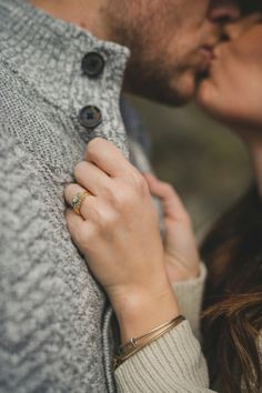 a man and woman kissing each other while wearing rings