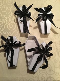 four white boxes with black ribbons and bows on the top one is empty, the other two are open