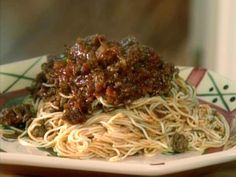 a white plate topped with spaghetti and meat