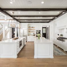 a large kitchen with white cabinets and wooden floors