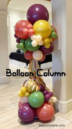 a bunch of balloons that are on top of a pole in the hallway, with words balloon column