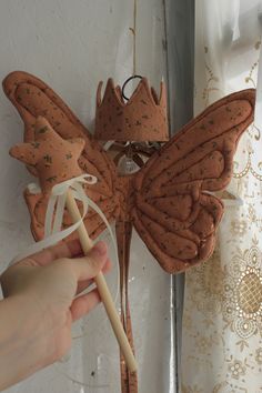 a person holding a stick near a butterfly decoration