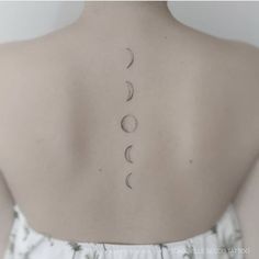 the back of a woman's neck with three phases on it