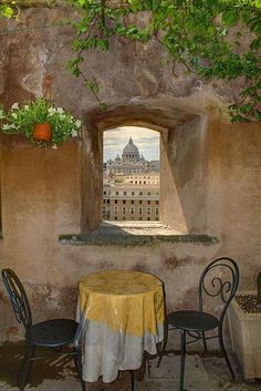 a table and chairs in front of a window with a view of the city below