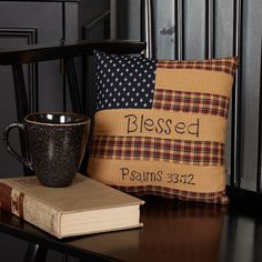 a coffee mug sitting on top of a wooden table next to a pillow and book