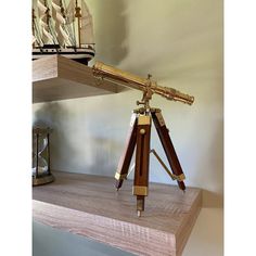 a telescope sitting on top of a wooden shelf