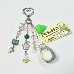 a keychain with charms attached to it on a white surface next to a card