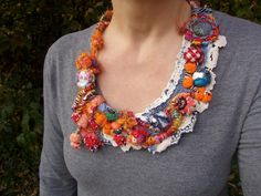 a woman wearing a multi colored necklace with buttons and beads on it's neck