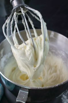 a whisk in a metal bowl filled with cream