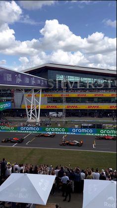 an aerial view of a race track with cars on it and people standing in the stands