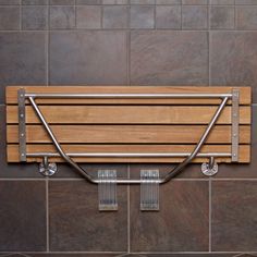 a wooden bench mounted to the side of a wall with two metal brackets on it