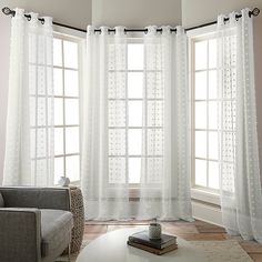 a living room filled with furniture and white curtains