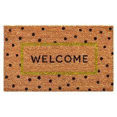 a welcome mat with black dots on it