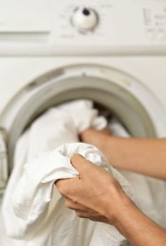 a person is holding something in front of a washer and drying it on a towel