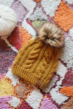 two balls of yarn sitting on top of a blanket next to each other with one ball of yarn in the middle