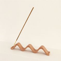 a pair of knitting needles sitting on top of a wooden stand