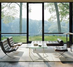 a living room filled with furniture and large windows