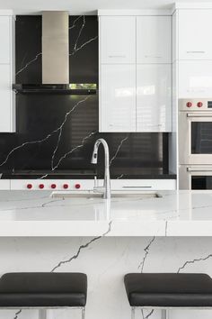 All Quartz Island and Black Backsplash in Black White Kitchen