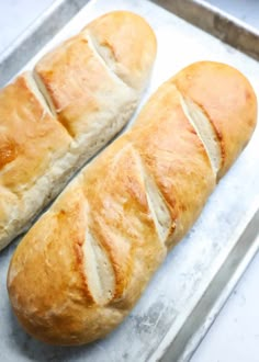 two loaves of bread sitting on top of a pan