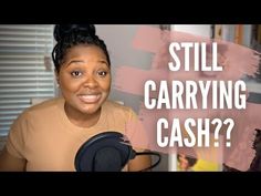 a woman holding a microphone with the words still carrying cash? in front of her