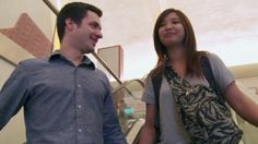 two people standing next to each other near an escalator