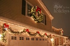 christmas lights on the side of a house with a wreath hanging from it's roof