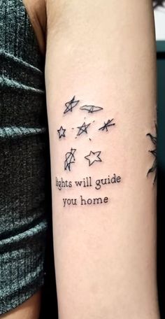 a person with a tattoo on their arm that says, lights will guide you home