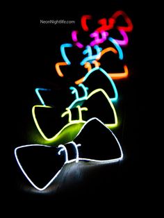 some neon lights that are on the side of a wall with a bow tie in front of it