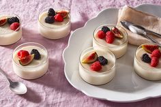 small desserts are arranged on a plate with spoons and napkin next to them