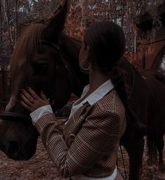 a woman standing next to a brown horse