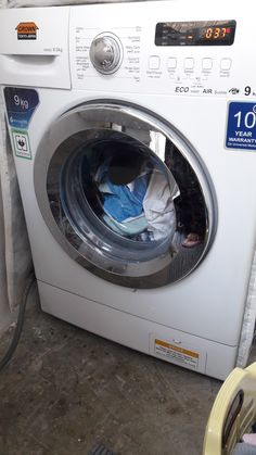 a washing machine sitting inside of a room next to a dryer and drying bag