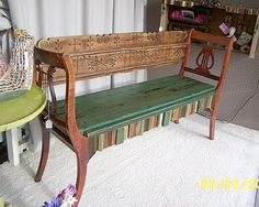 a wooden bench sitting on top of a white rug next to a green table and chair