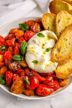 a white plate topped with bread and tomatoes