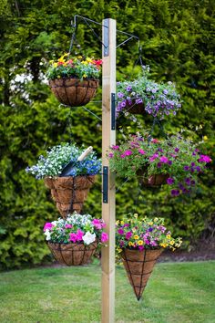 a tall wooden pole with hanging baskets filled with flowers