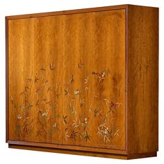 a wooden cabinet with floral designs painted on the front and side panels, along with two doors