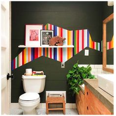 a bathroom decorated with colorful striped wallpaper and wooden furniture, including a toilet in the foreground