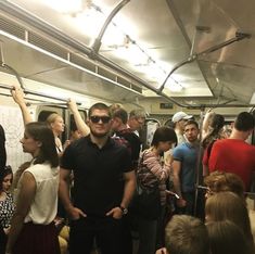 a group of people standing on a subway train