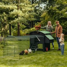 a man and woman standing next to a chicken coop